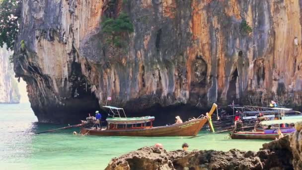 Ταϊλανδέζικη βάρκα Longtail επιπλέουν στη θάλασσα από την παραλία ενάντια σε βραχώδη γκρεμό — Αρχείο Βίντεο