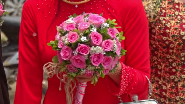 Closeup meisje in rood houdt bruiloft roze roos boeket — Stockvideo
