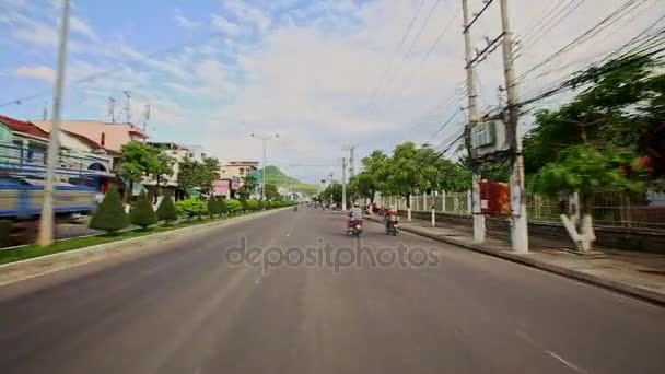 Scooters Drive вдоль Wide Street Past Houses тропические растения — стоковое видео