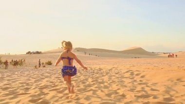 Kumsalda çıplak ayakla çalışan küçük kız