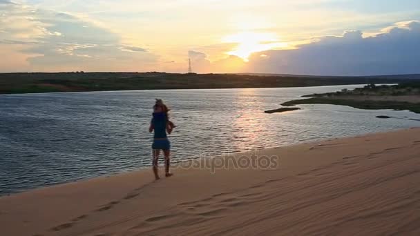 Мать с дочерью, идущей по песчаной дюне — стоковое видео