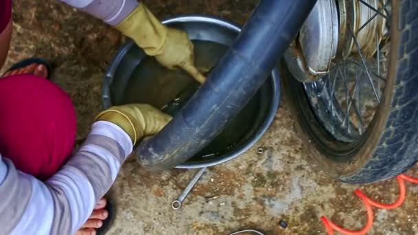 Vietnamese woman repairing tyre of motorcycle — Stock Video