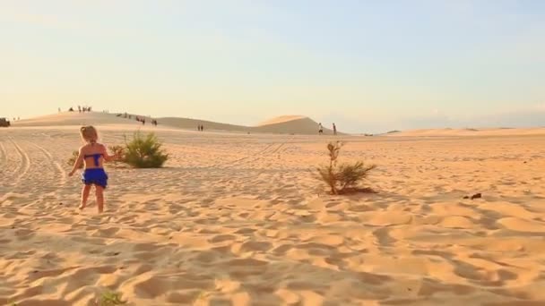 Маленька дівчинка біжить босоніж на піску — стокове відео