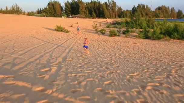 Мать с дочерью, идущей по песчаной дюне — стоковое видео