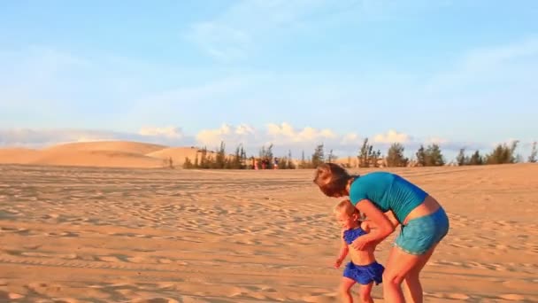 Mère avec fille marchant par dune de sable — Video