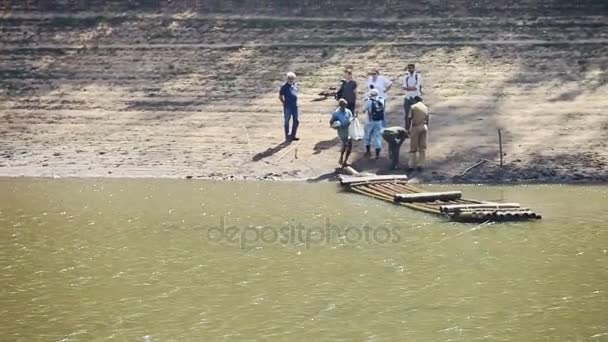 Туристів чекають великі дерев'яні пліт — стокове відео