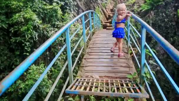 Little girl walks along small bridge — Stock Video