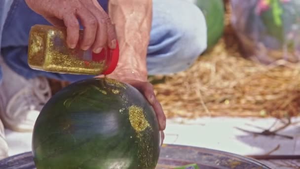 Hombre vierte polvo de oro a la sandía tallada — Vídeos de Stock