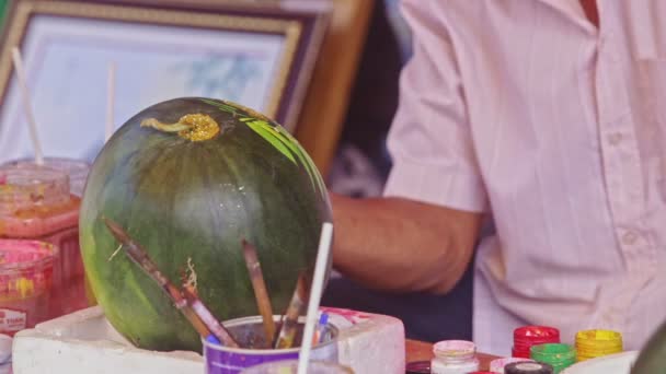 Homem desenha quadro com escova na melancia esculpida — Vídeo de Stock