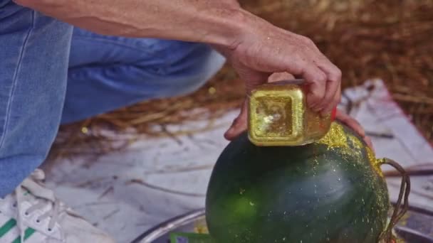 Hombre vierte polvo de oro a la sandía tallada — Vídeos de Stock
