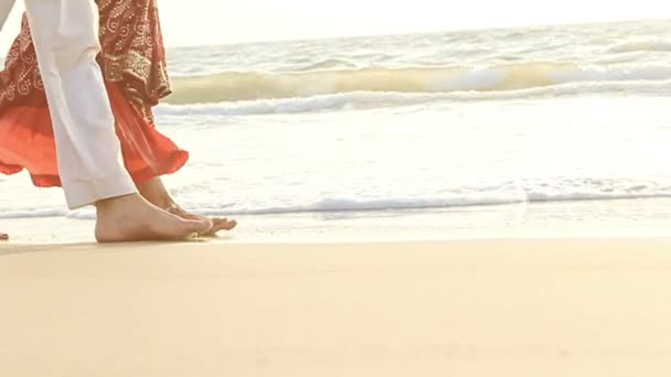 Facet z Dziewczyna, chodzenie boso, w wodzie wzdłuż plaży — Wideo stockowe