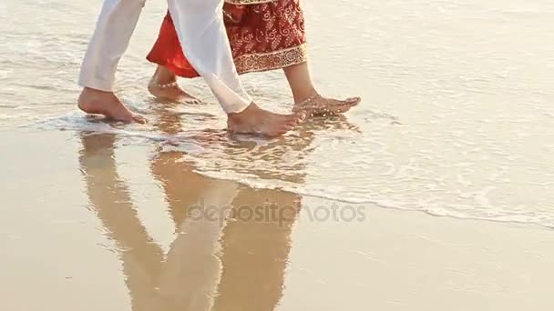 Ragazzo con ragazza camminare a piedi nudi in acqua lungo la spiaggia — Video Stock
