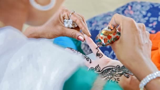 Майстер Індійська дівчинка малює квіткові візерунки на пальці — стокове відео