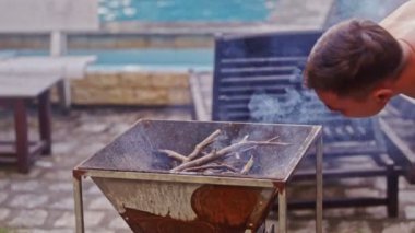 Adam metal mangal üzerinde eğilir 