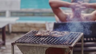 Barbekü ateşe et parçası pişirir 