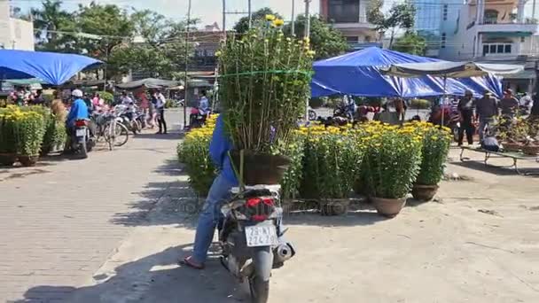 Homem senta-se em scooter com flores amarelas — Vídeo de Stock