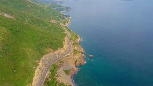 Carretera en empinadas laderas rocosas a lo largo del océano — Vídeos de Stock