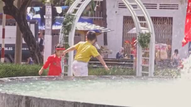 Junge und Mädchen spielen am Straßenbrunnen — Stockvideo