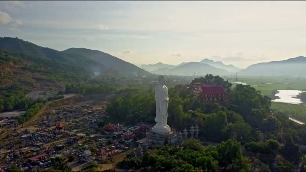 Буддха статуя возле буддийского храма и деревни — стоковое видео