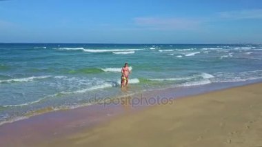 Anne ve kızı yürüyüş ve okyanusta oynarken