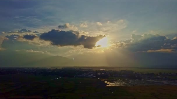 Солнце за светлыми облаками в голубом небе — стоковое видео