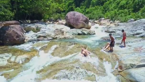 Çocuklar slayt rocky nehir dağ taşlarının üzerinde — Stok video