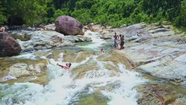 Niños se deslizan sobre piedras del río rocoso de montaña — Vídeos de Stock