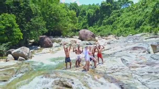 Діти стоять серед гірський потік і розмахуючи руками — стокове відео