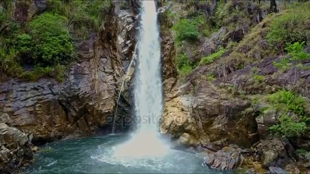 Озеро среди скалистых берегов с горным водопадом — стоковое видео