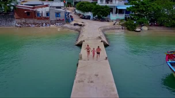 Familie läuft auf Seebrücke und springt ins Meer — Stockvideo