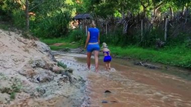 Anne ve kızı akışı suda yalınayak oynamak 