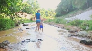 Anne ve kızı akışı suda yalınayak oynamak 