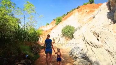 Anne ve kızı çıplak ayakla peri akışta yürüyüş