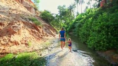 Anne ve kızı akışı suda yalınayak oynamak 