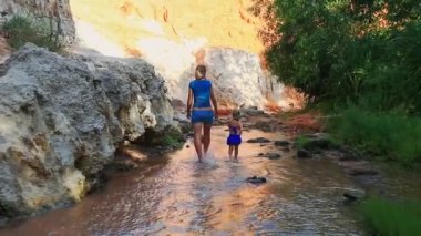 Anne ve kızı akışı suda yalınayak oynamak 