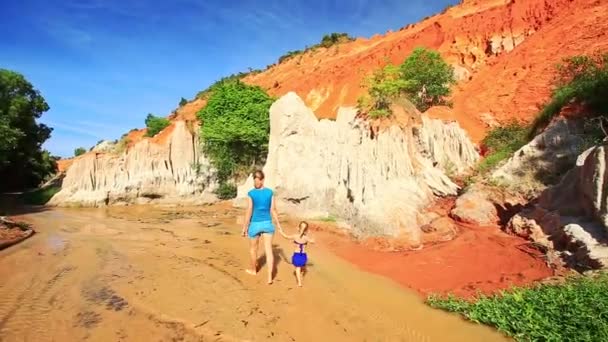 Mère et fille marchant pieds nus sur le ruisseau de fées 