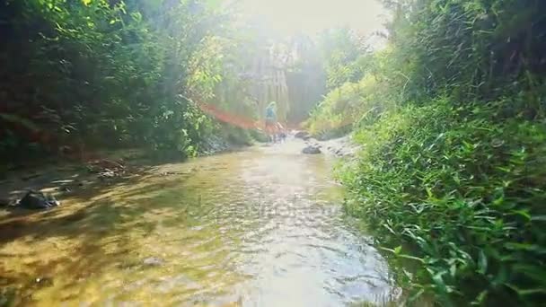 Mother and daughter play barefoot in stream water — Stock Video