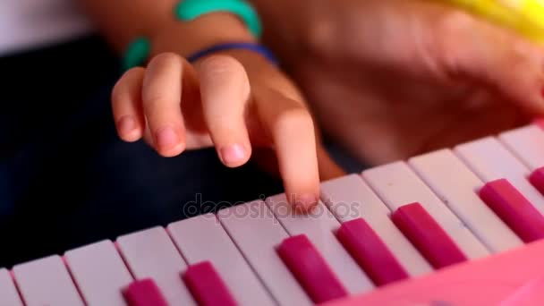 Дівчина грає на іграшковому піаніно клавіатурі — стокове відео