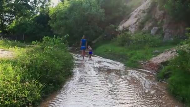 Мати і дочка грають босоніж у струмковій воді — стокове відео