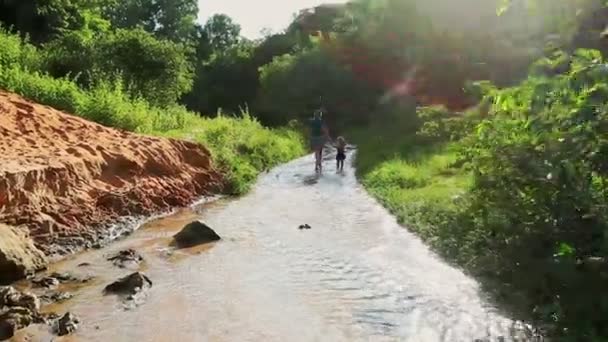 Madre e figlia giocano a piedi nudi in acqua corrente — Video Stock