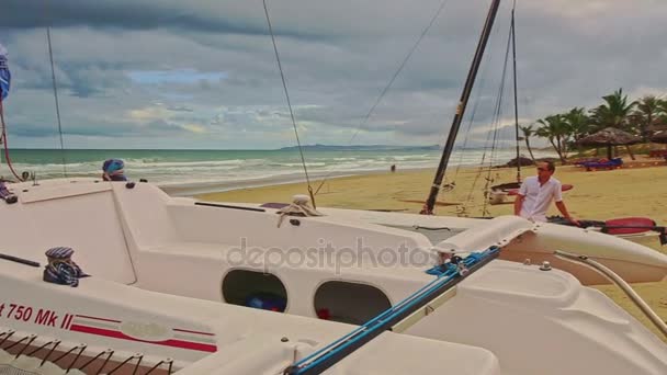 Моряк на красивой моторной лодке на песчаном пляже — стоковое видео