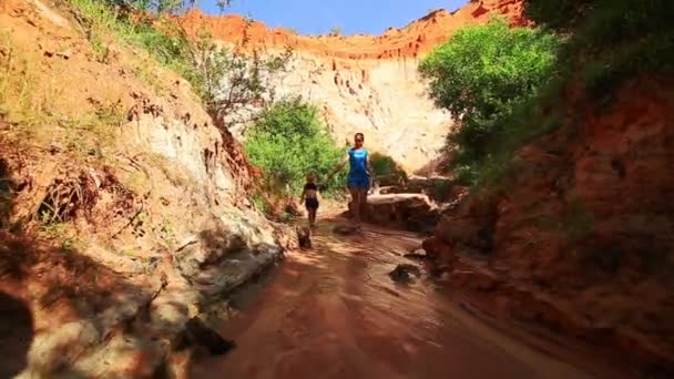 Mère et fille marchant pieds nus sur le ruisseau de fées 