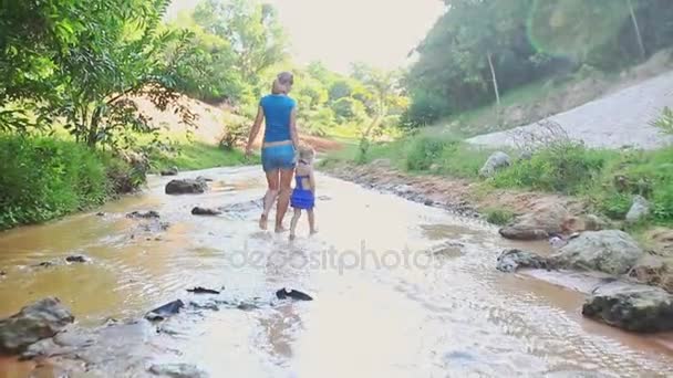 Мать и дочь играют босиком в речной воде — стоковое видео