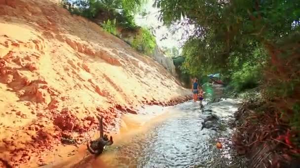 Мати і дочка грають босоніж у струмковій воді — стокове відео