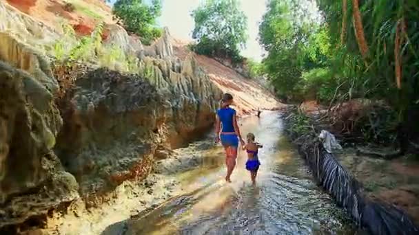 Madre e hija juegan descalzas en el agua del arroyo — Vídeo de stock