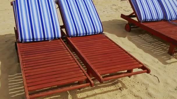 Chaise-longues de madeira na praia de areia — Vídeo de Stock