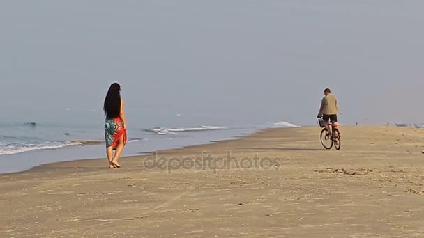 Man op fiets vangsten meisje op strand — Stockvideo