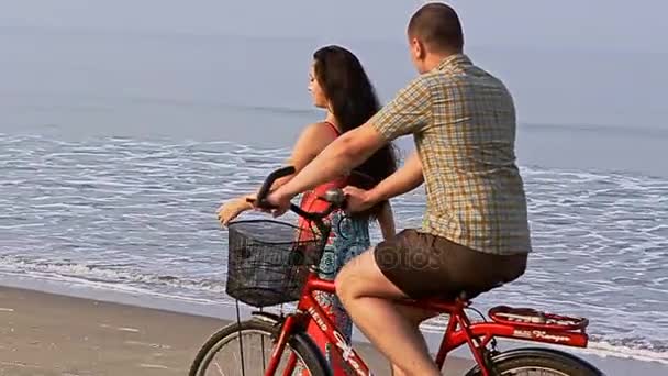 Homme sur vélo attrape fille sur la plage — Video