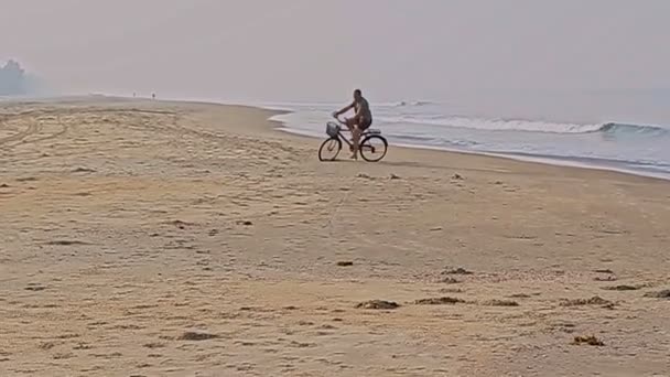 Adam okyanus plaj boyunca bisiklet sürmek — Stok video