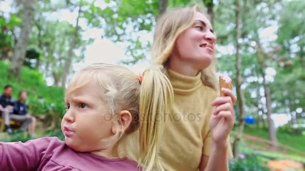 Mãe e menina comendo sorvete no banco — Vídeo de Stock